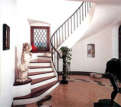 Яркий пример комбинированной лестницы: деревянная облицовка ступеней, бетонный косоур, металлические перила и балясины
